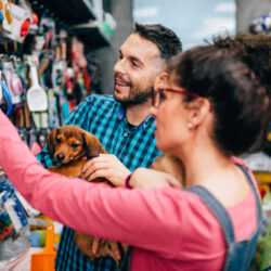 Happy,Couple,With,Their,Puppy,Buying,In,Pet,Shop.