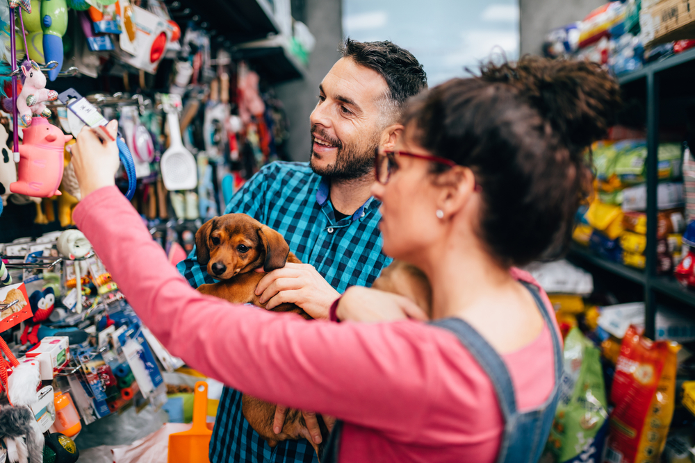 Happy,Couple,With,Their,Puppy,Buying,In,Pet,Shop.